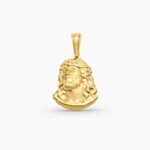 Gold pendant with a face design on a white background